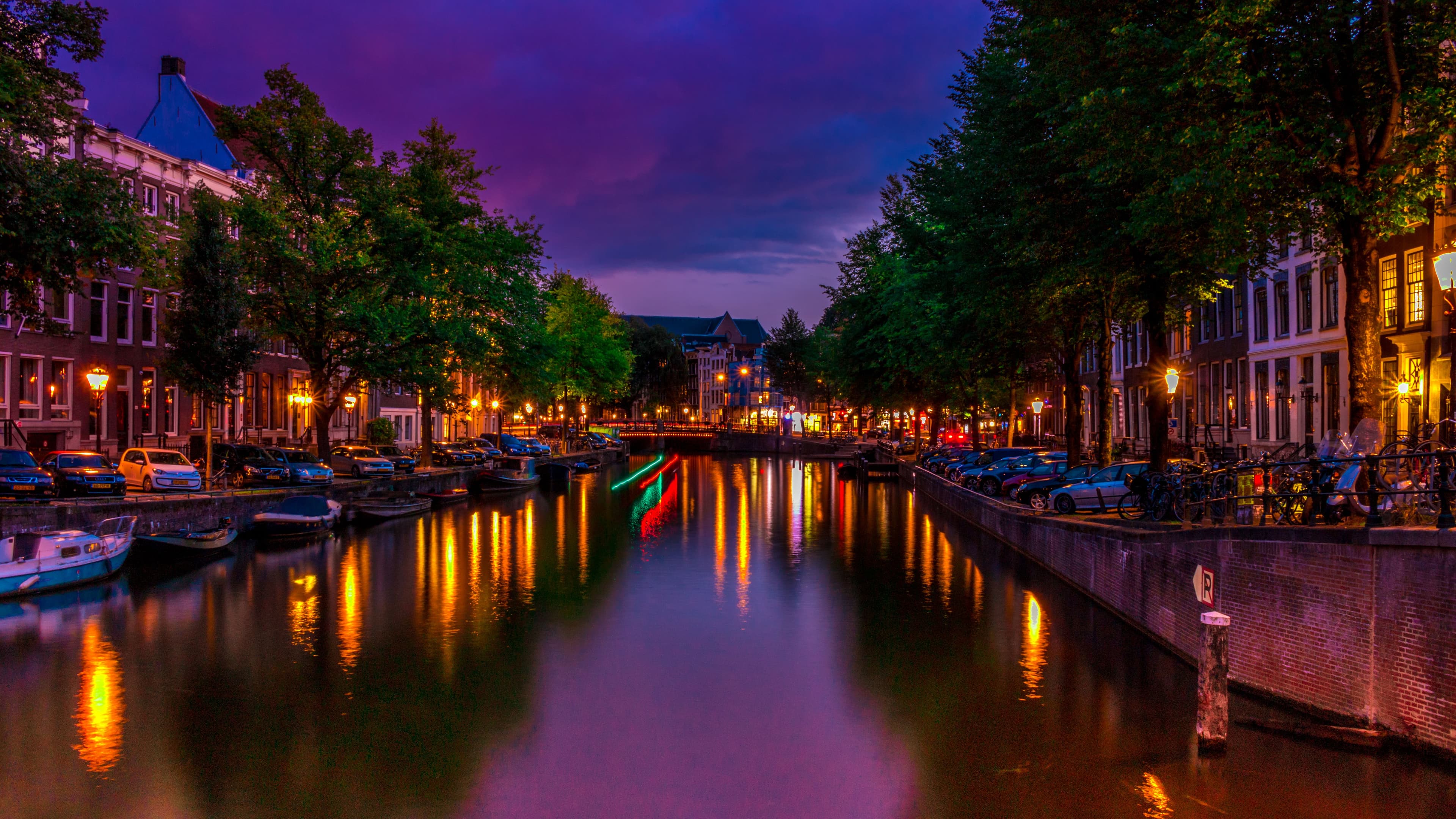 Amsterdam canal at blue hour with glowing street lamps